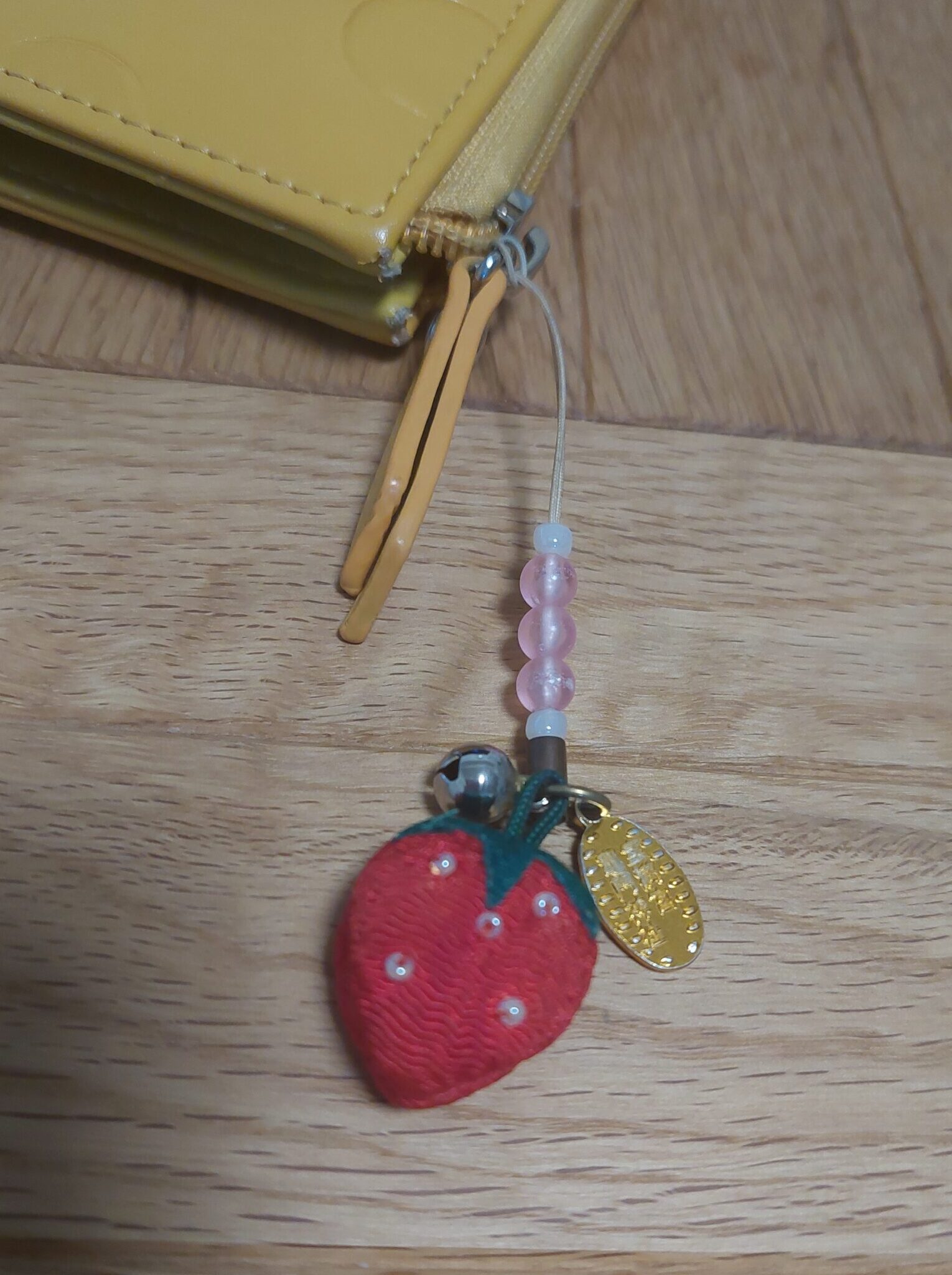 My cute strawberry charm from Kamado Shrine — attached to my phone for good luck in love.