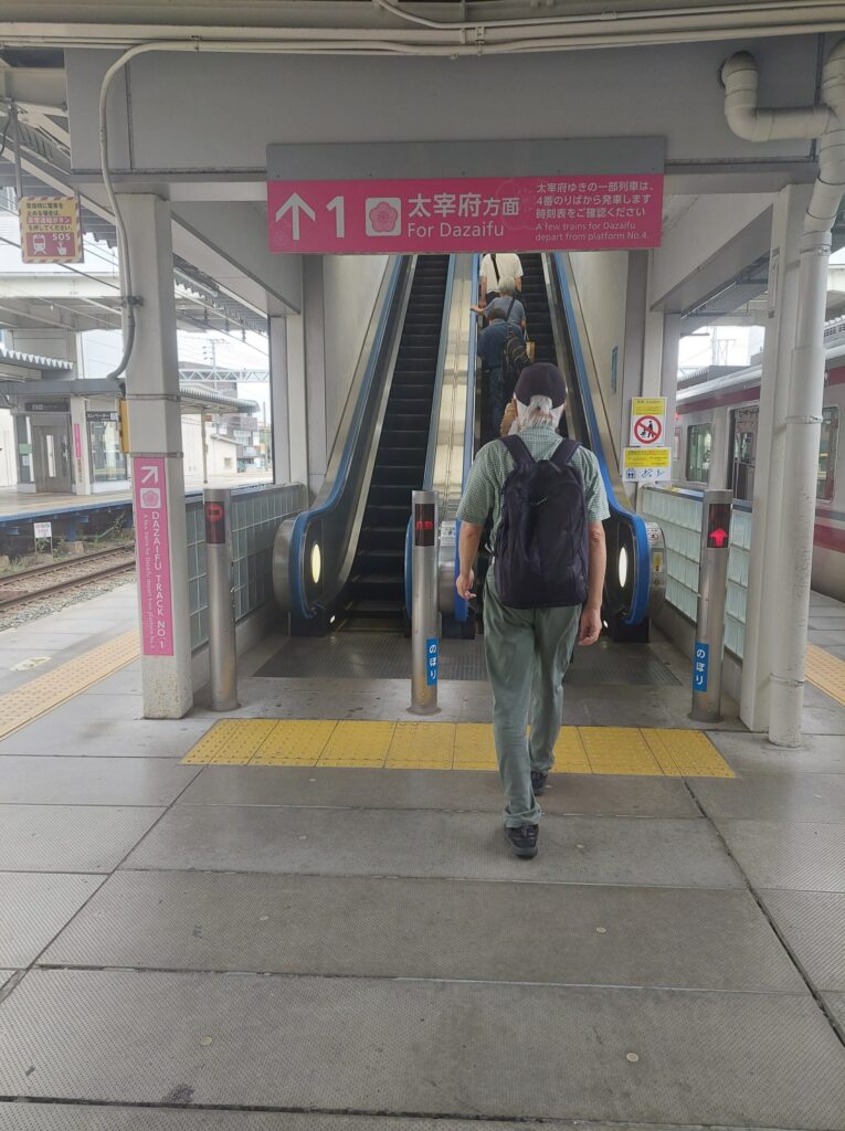 Escalator leading to the connecting passage toward the Dazaifu Line platform at Nishitetsu Futsukaichi Station.