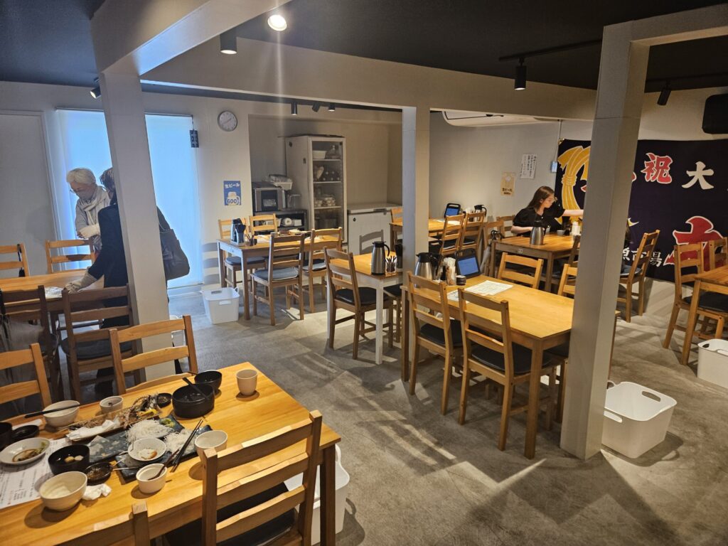 Interior of Sengyo Inokichi in Dazaifu, featuring clean dining tables and a casual atmosphere with counter seating.