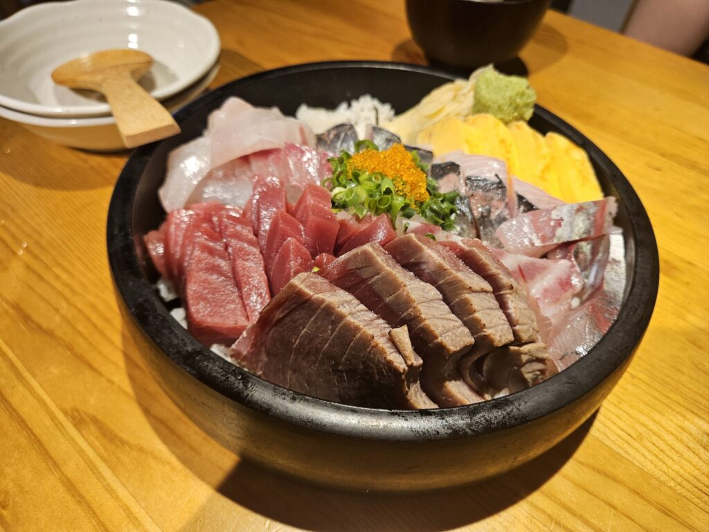 A large seafood rice bowl (kaisendon) at Sengyo Inokichi in Dazaifu, topped with thick-cut tuna, mackerel, sea bream, flying fish roe, and egg.