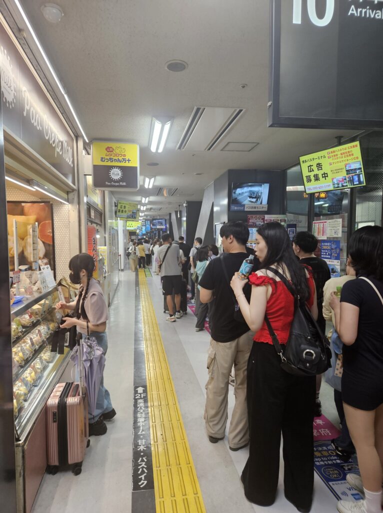 Travelers lining up at Hakata Station for the Dazaifu Liner Tabito bus to Dazaifu Tenmangu Shrine.
