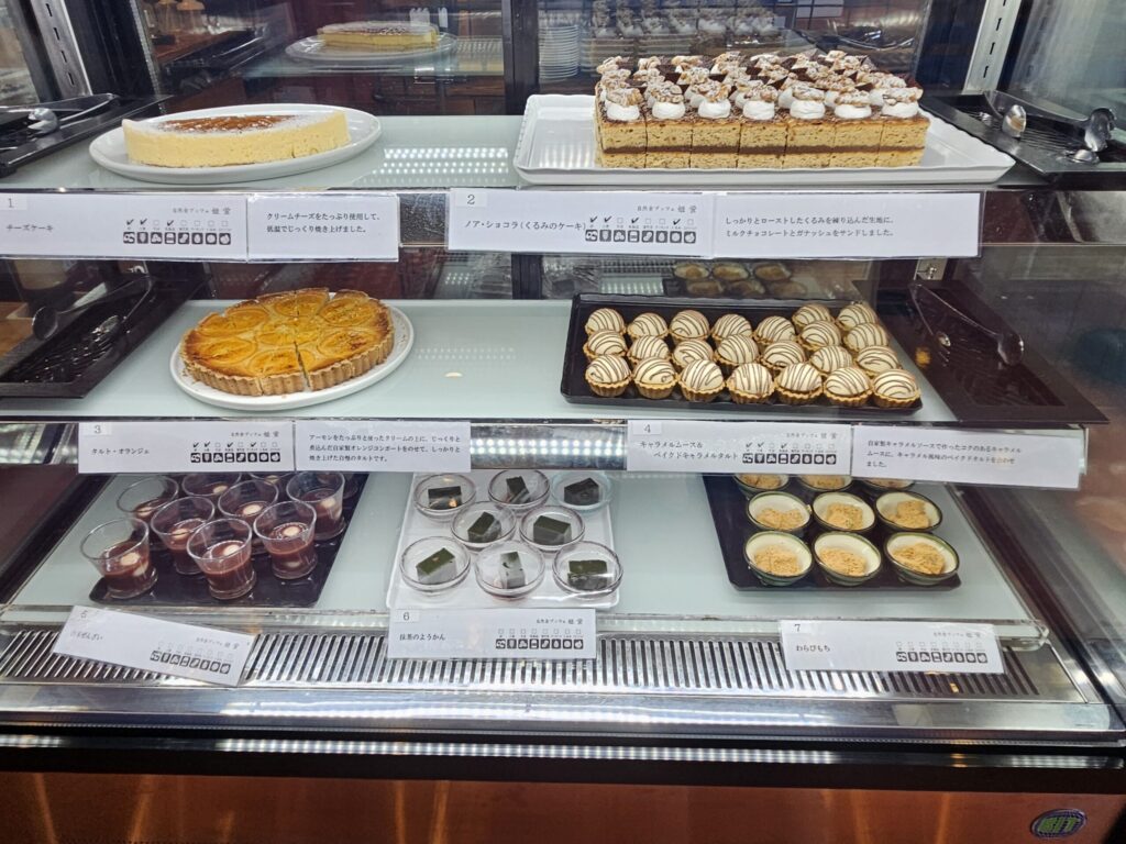 Dessert showcase 2 at the buffet in Tenpai no Sato, Chikushino, near Dazaifu Tenmangu Shrine — displaying a variety of cakes including orange tart.