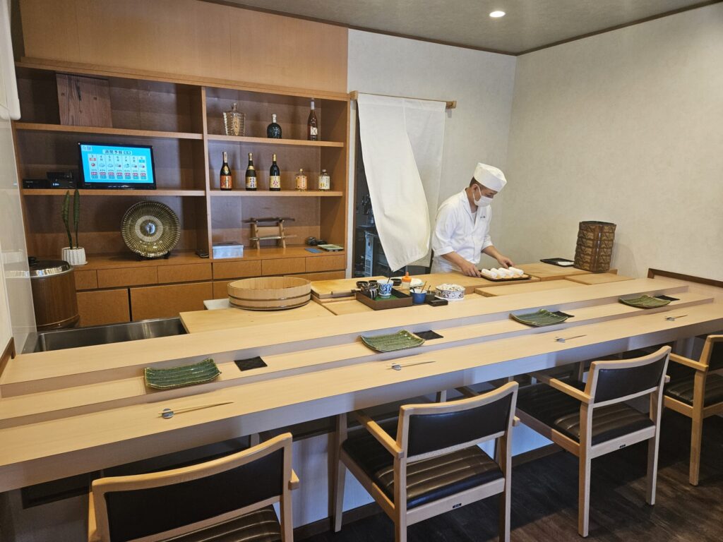 The counter and chef at Gin Sushi in Onojo, near Dazaifu — a calm, traditional sushi bar where guests can watch the chef’s craftsmanship up close.