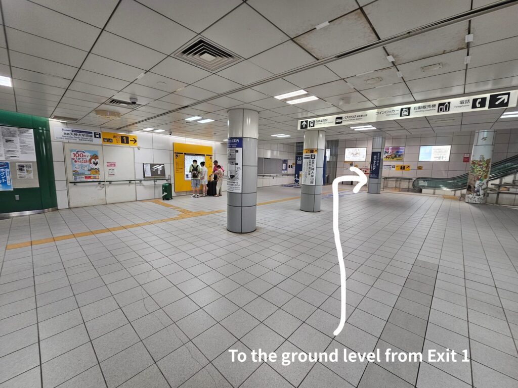Guidance sign inside Subway Yakuin Station with directions for transfer to Nishitetsu Yakuin Station and Dazaifu access.