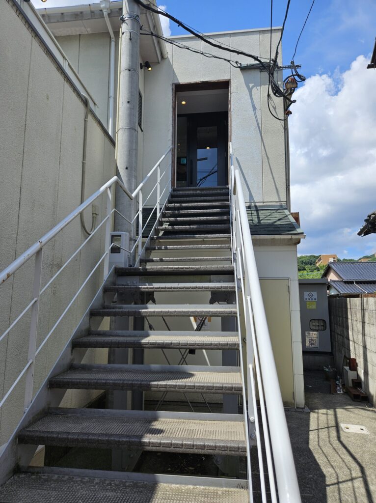 White staircase leading up to the entrance of Chuta no Kissa café near Dazaifu Tenmangu Station.