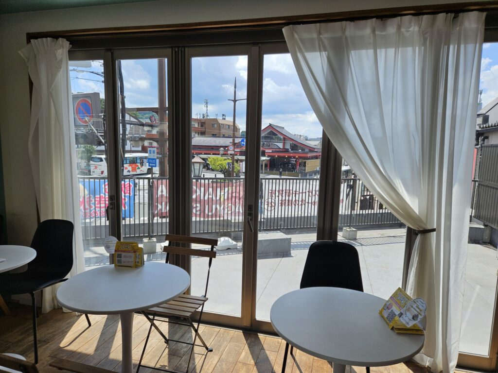 View from inside Chuta no Kissa café toward the terrace overlooking Dazaifu Tenmangu Station square.