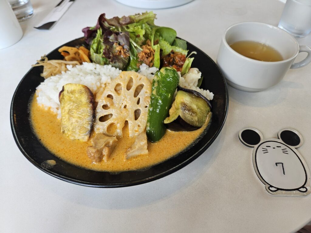 Massaman curry set with soup at Chuta no Kissa café, topped with colorful fried vegetables.