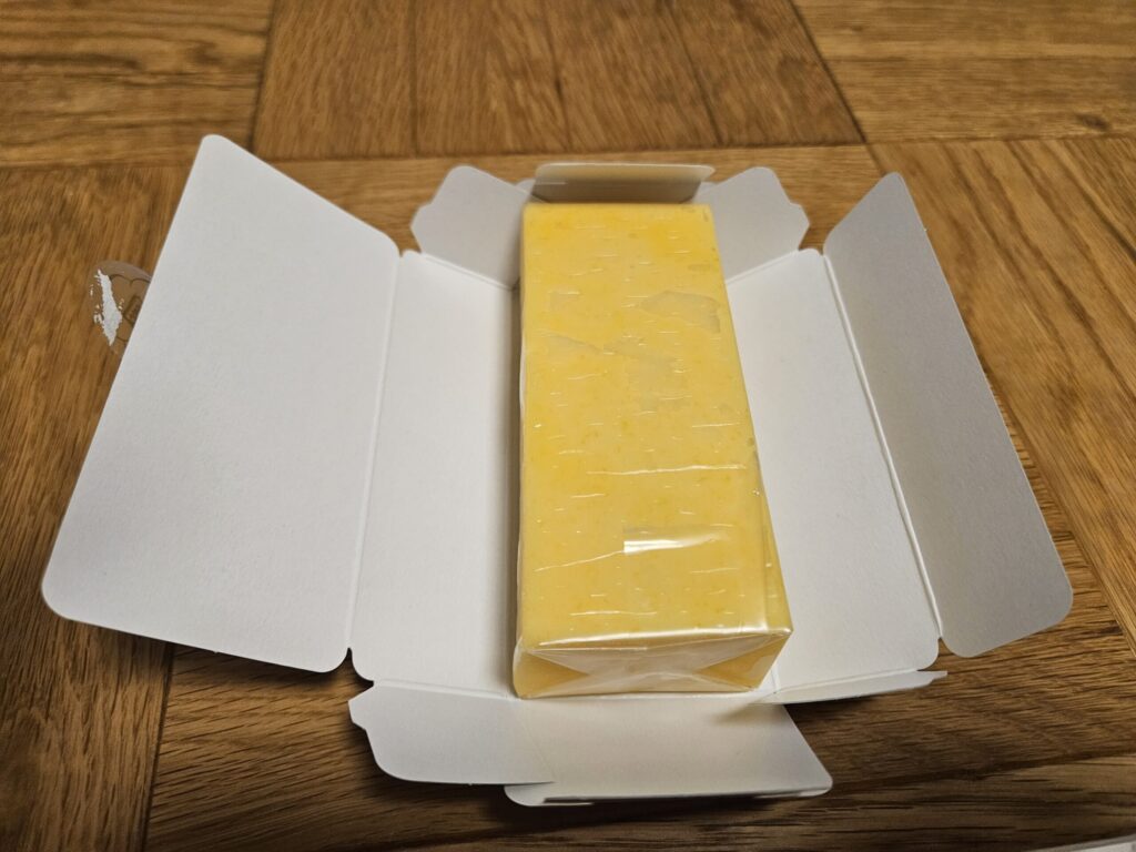 Inside the box of Homanzan from Baien in Dazaifu, revealing the smooth yellow Japanese confection.