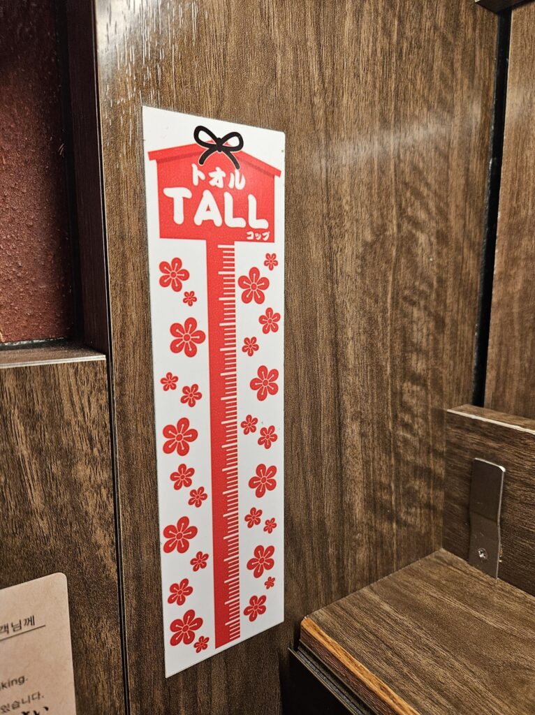 Ichiran Dazaifu Sando Ten interior sign explaining the “TALL Cup,” a lucky item symbolizing passing exams.