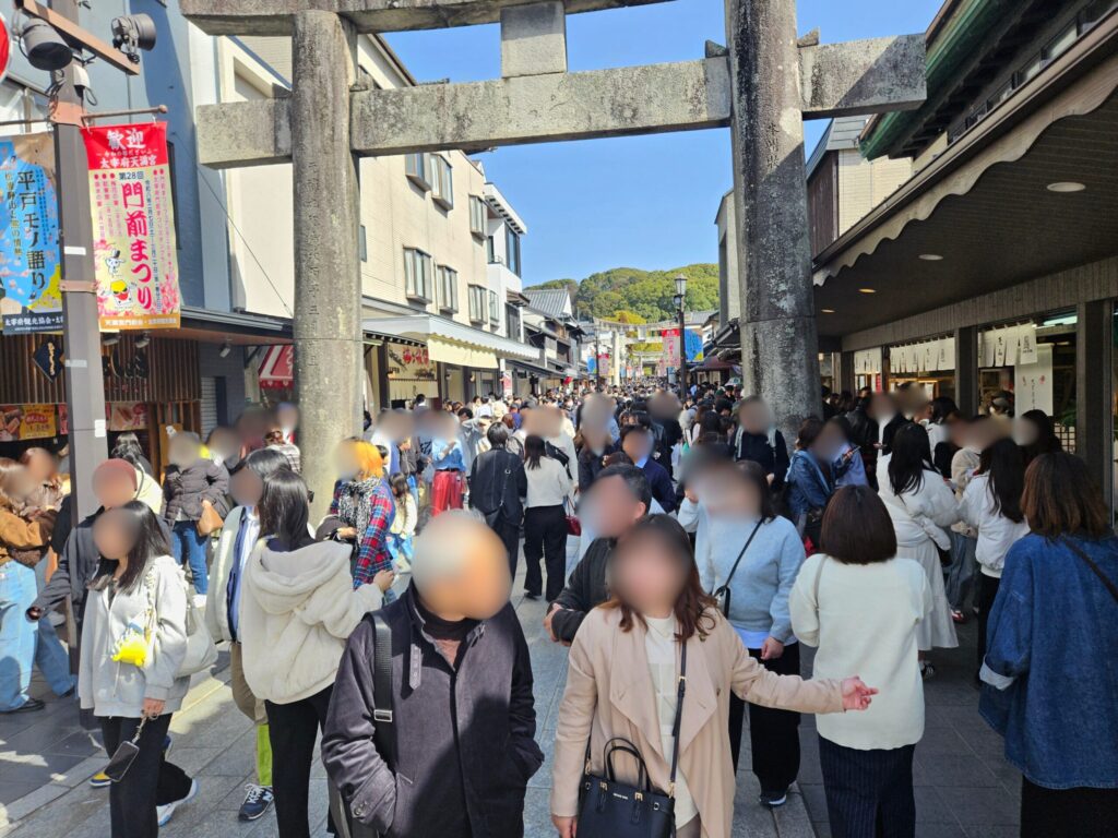 Crowded approach to Dazaifu Tenmangu on February 23, 2026, with heavy holiday visitors filling the street during peak plum blossom season.